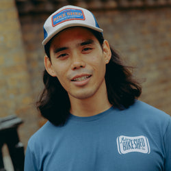 Model wearing navy blue t-shirt with 'Moto Bikeshed co'  logo - front