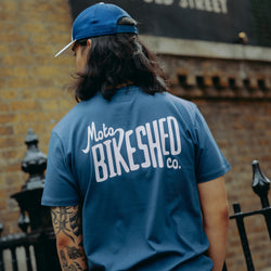 model wearing navy blue t-shirt with 'Moto Bikeshed co'  logo - back
