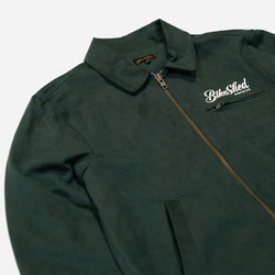 Green motorcycle jacket with a Bike Shed Moto Co brand logo on a white background