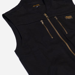 Black motorcycle vest with gold zippers with a Bike Shed Moto Co logo on a white background