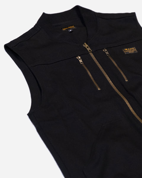 Black motorcycle vest with gold zippers with a Bike Shed Moto Co logo on a white background