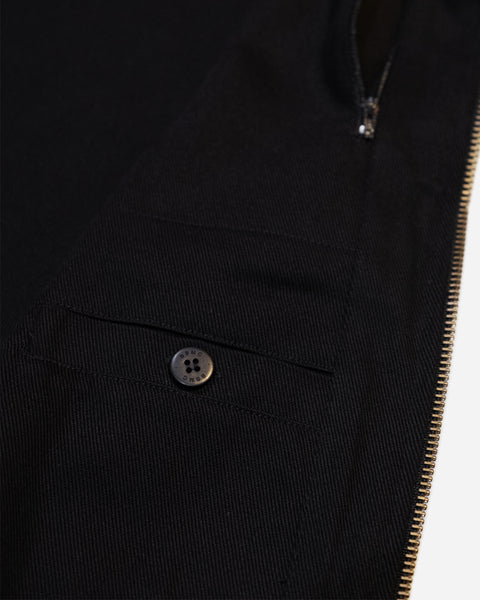 Close-up of a Black motorcycle vest with gold zipper and visible Bike Shed Moto Co brand logo on a white background
